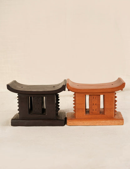 Two wooden stools, one black and one brown, on a beige background
