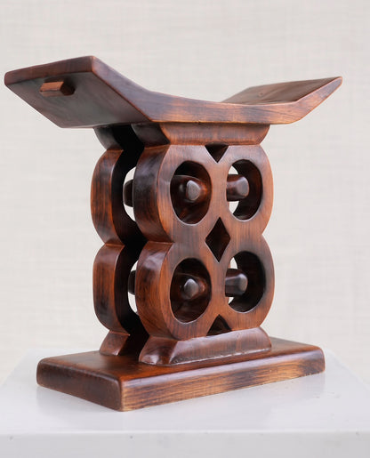 Wooden stool with intricate design on a white background