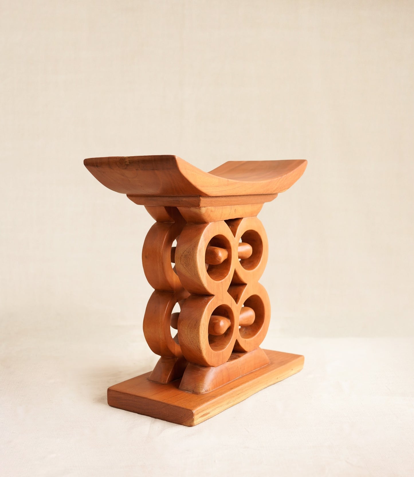 Wooden stool with circular design on a beige background