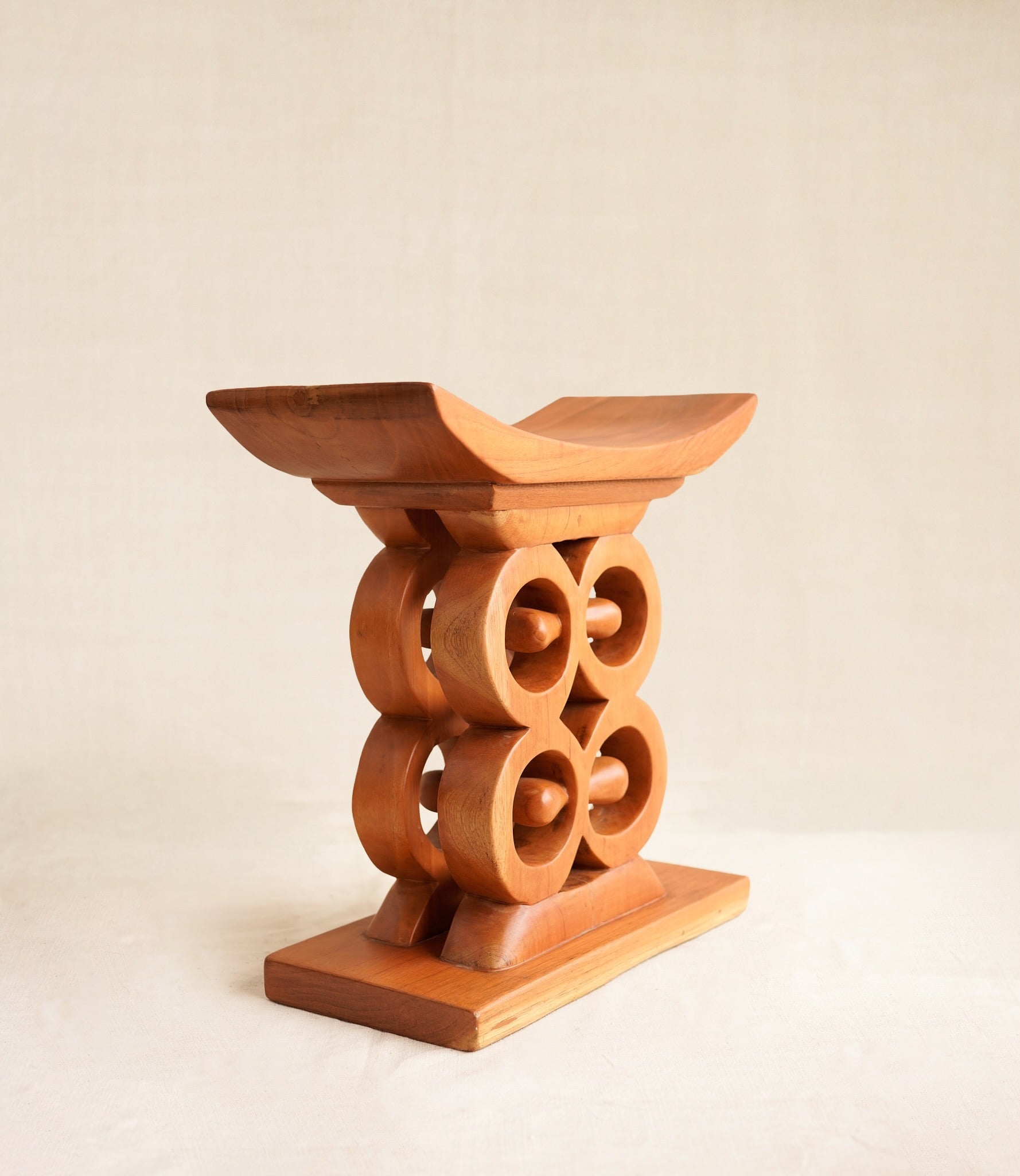 Wooden stool with circular design on a beige background