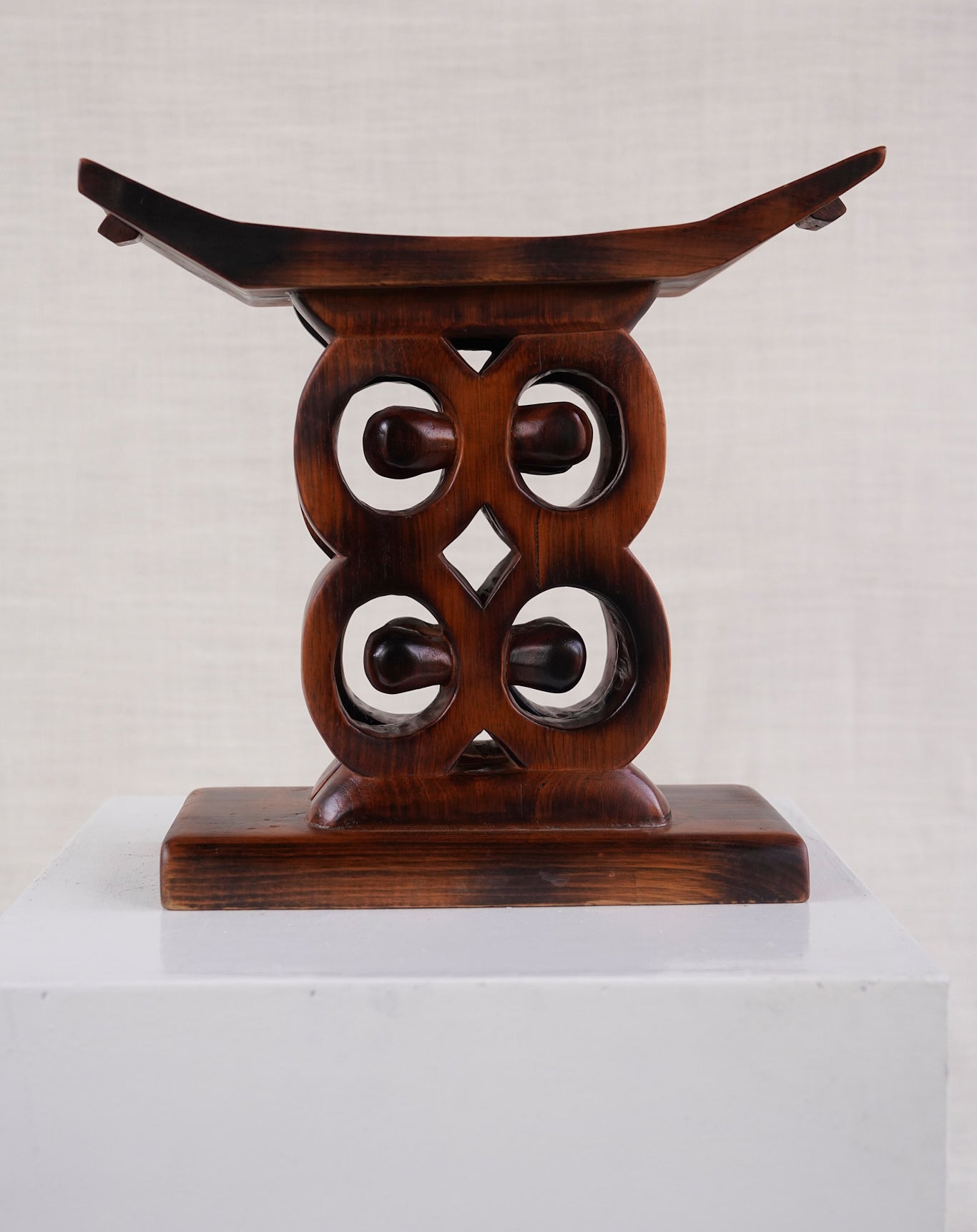 Wooden stool with intricate design on a white background