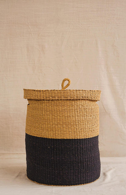 Woven basket with a lid on a neutral background