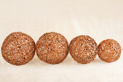 Four woven rattan balls on a beige background